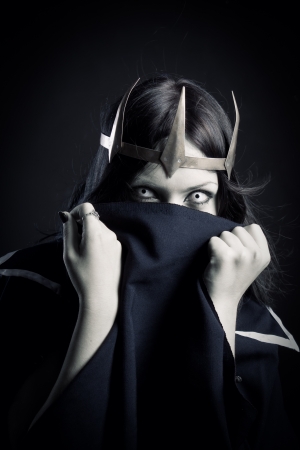 Pretty girl with crown posing over dark backgroundの写真素材