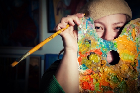 Young funny artist with palette and brushの写真素材