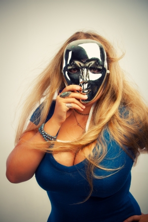 Pretty young woman in mask posing over white backgroundの写真素材