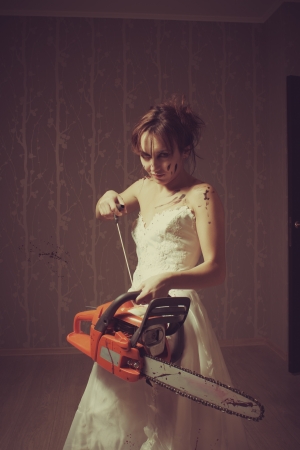 Crazy bloody bride with chainsaw  Indoors shooting の写真素材