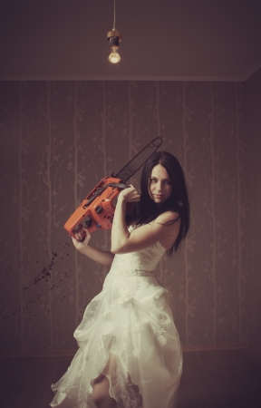 Pretty seductive bride with chainsaw  Indoors shooting の写真素材