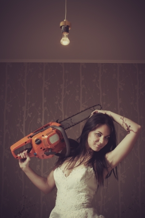 Seductive bride with bloody chainsaw  Indoors shooting の写真素材