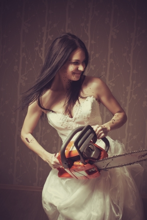 Seductive bride with bloody chainsaw  Indoors shooting の写真素材