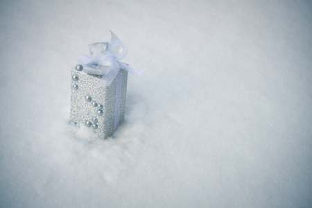 White christmas box laying in snow. Outdoors shooting. の写真素材
