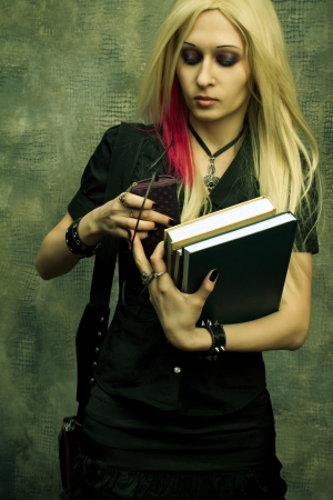 Naughty gothic girl listening music in uniform with books の写真素材