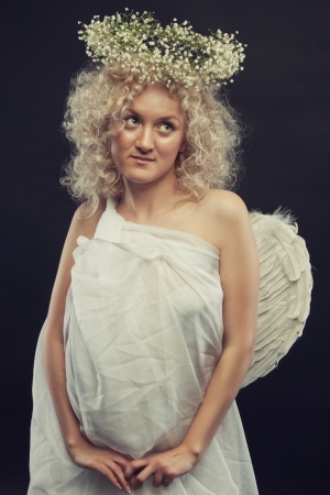 Cute angel with wings and nimbus over dark backgroundの写真素材