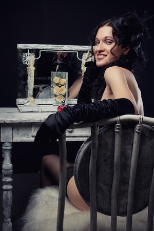 Theatre actress sits on a white chair  Rear view 