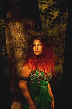 Redhead pretty young woman standing in the forest