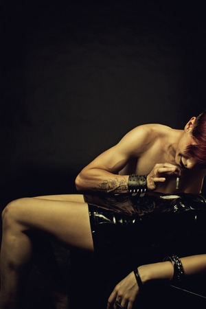 Young muscular redhead man snorting cocain with dollar.の写真素材