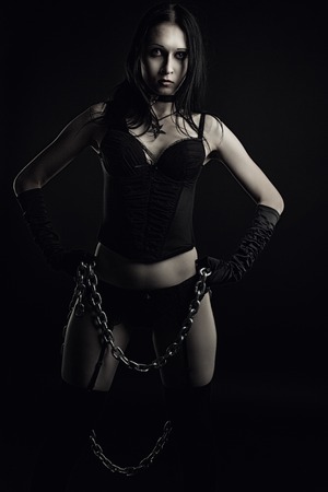 Seductive girl in black lingerie with chains over dark backgroundの写真素材