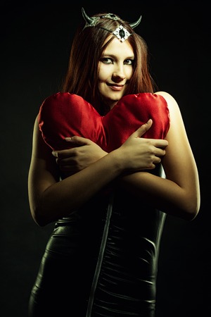 Sexy girl holding heart over dark backgroundの写真素材