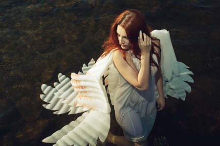 Pretty readhead angel standing in waterの写真素材