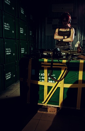 Pretty redhead girl in a storage full of weaponの写真素材