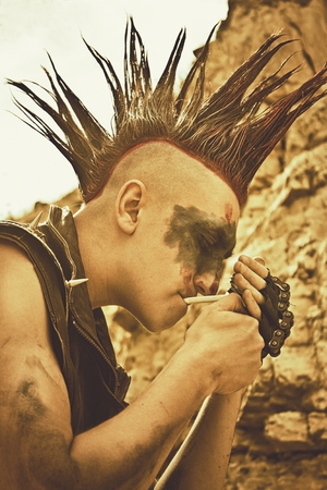 Angry dirty raider smoking cigarette over post-apocalyptic landscapeの写真素材