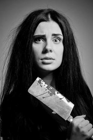 Seductive scared girl posing with chopper over blue  background