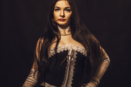 Seductive old-fashioned lady in corset over black backgroundの写真素材