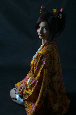 Pretty geisha in kimono sitting on the floorの写真素材