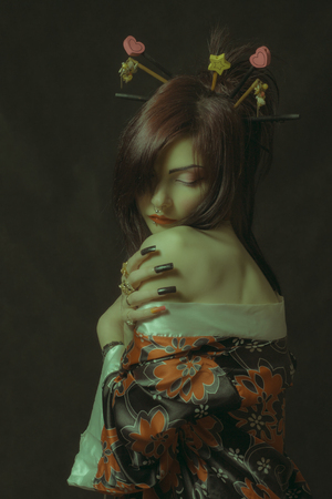 Pretty asian girl in kimono posing over dark backgroundの写真素材