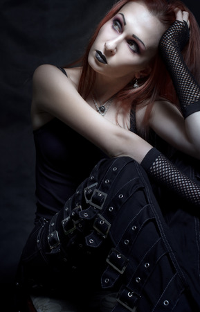 Beautiful gothic girl posing over dark backgroundの写真素材