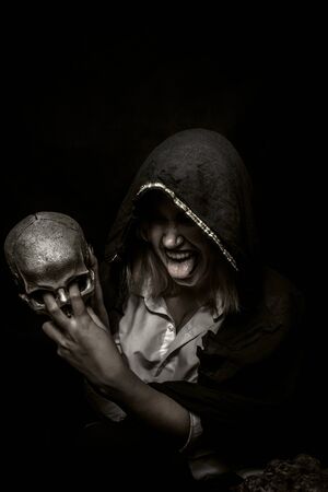 Crazy shaman with skull posing over dark backgroundの写真素材
