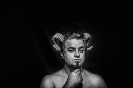 Horned faun posing over dark backgroundの写真素材