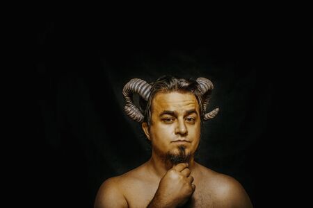 Horned faun posing over dark backgroundの写真素材