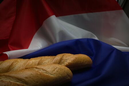 Closeup of two baguettes laying on French flagの写真素材