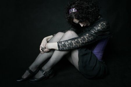 Young cute elegant oldfashioned lady sitting on the floorの写真素材