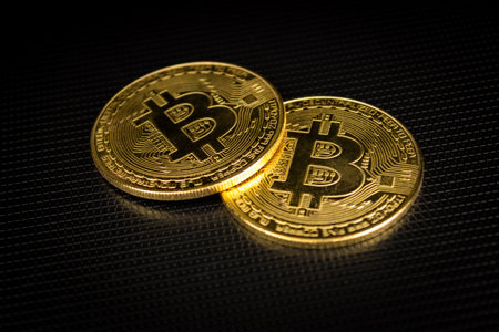 Bitcoins laying on a dark surface in a soft light