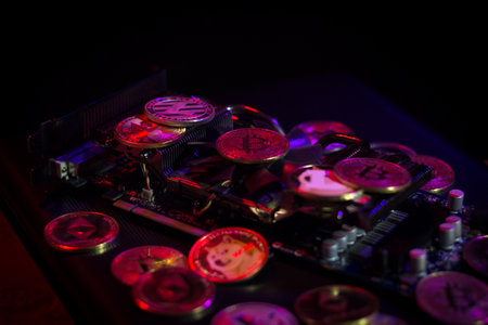 Pile of cryptocurrencies on videocard in neon light