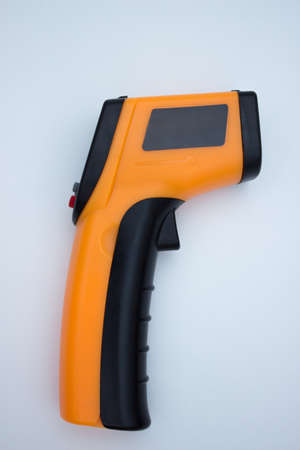 Infrared thermometer (thermometer gun) for measuring temperature over white background. Covid-19...