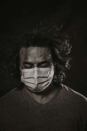 Man wearing medical mask over dark background