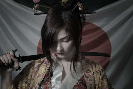 Kawaii japanese girl with katana posing over japanese flag