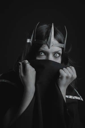Pretty girl in crown posing over dark backgroundの写真素材