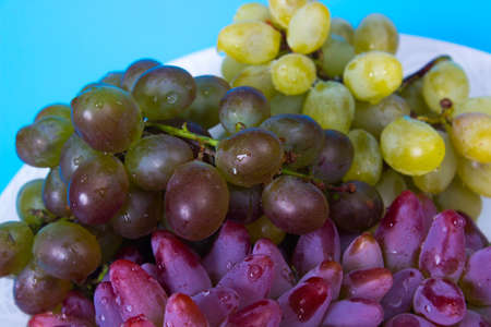 Grapes in a plate over blue backgroundの写真素材
