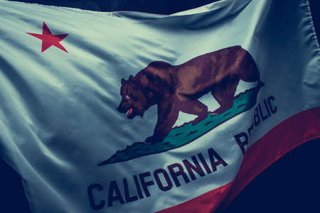 Waving California state flag over dark backgroundの写真素材