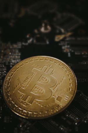 One bitcoin laying over graphic videocard