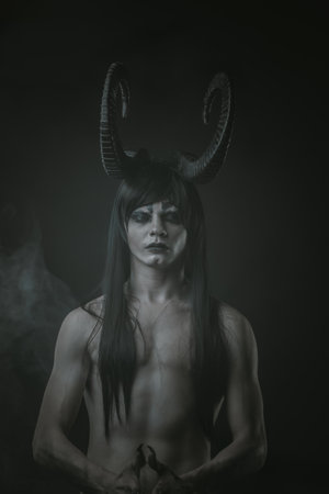 Horned guy posing over dark background
