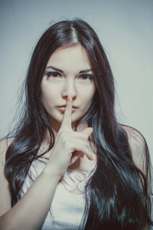 Cute brunette asian girl posing over grey backgroundの写真素材