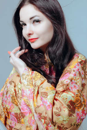 Pretty asian young woman in kimono over grey backgroundの写真素材