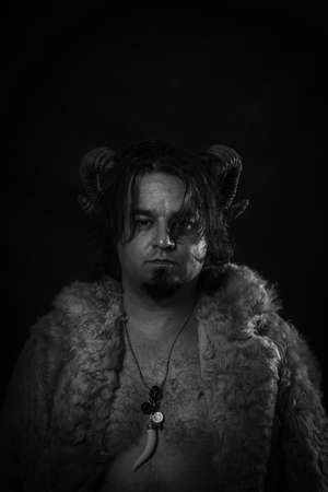 Horned faun standing over dark background