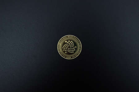 One IOTA coin over dark background