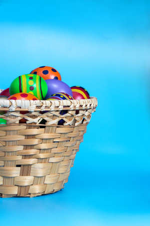 Painted easter eggs in busket over blue background
