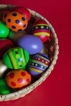 Painted easter eggs in basket over red background