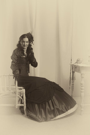 Old fashioned lady in black sitting on vintage chair
