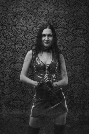 Young brunette woman in red latex dressの写真素材