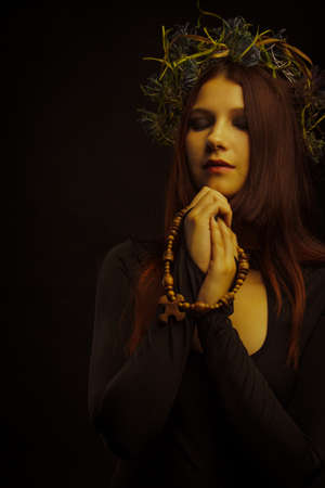 Beautiful woman praying over dark background