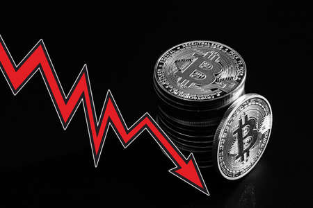 Bitcoins with red arrow. Fall of bitcoin concept.