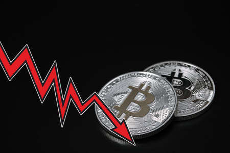 Bitcoins with red arrow. Fall of bitcoin concept.