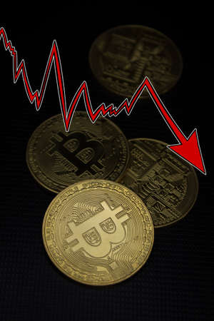 Bitcoins with red arrow. Fall of bitcoin concept.の写真素材